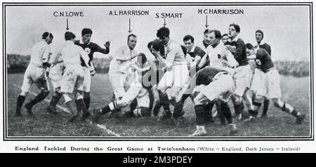 Eine Szene aus dem Rugby-Gewerkschaftsspiel England gegen Irland in Twickenham, 17-12 von England bei der fünf-Nationen-Meisterschaft gewonnen. Das Spiel wurde von König George V. angesehen, dem ersten Mal, dass er seit seinem Beitritt an einem internationalen Wettkampf teilgenommen hatte. Hier werden englische Spieler (in Weiß) von den irischen Forwards angegriffen. Stockfoto