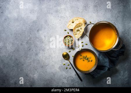 Kürbissuppe im Topf am Steintisch. Stockfoto