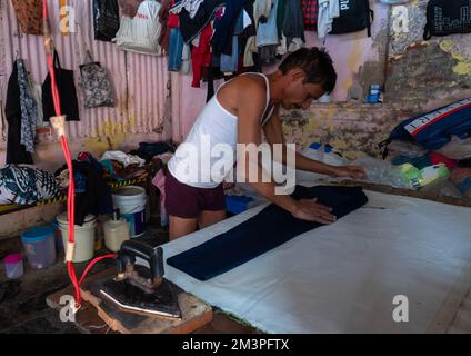 Wäschereipersonal bügelt in Dhobi Ghat, Maharashtra, Mumbai, Indien Stockfoto