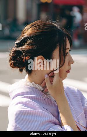 Porträt eines jungen und wunderschönen japanischen Mädchens, das das traditionelle Kimono-Kleid in den Straßen von Asakusa trägt Stockfoto