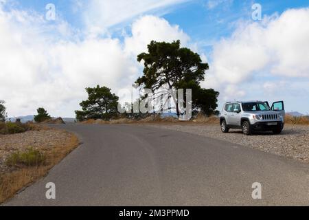 Ein weißer Jeep Renegade parkt an einer Straße in einer typischen Flusslandschaft. Rhodos-Insel, Griechenland. Oktober 09,2022 Stockfoto