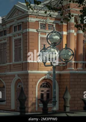 Bangkok, Thailand - 07. Dez. 2022 - Straßenlaternen auf Metallmast vor einem wunderschönen klassischen Backsteingebäude. Komposition im Stadtpark, Stockfoto