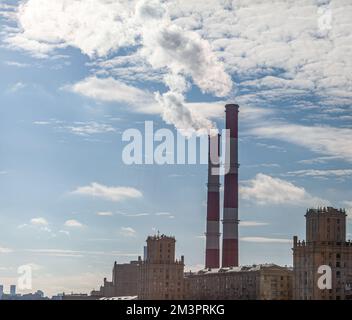 CHP in der Stadt. Aus den Wärmerohren des Kraftwerks steigt Rauch in den Himmel. Rohr aus Blockheizkraftwerk KWK oder Kraft-Wärme-Kopplung gegen BA Stockfoto