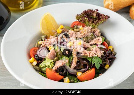 Thunfischsalat in einer Schüssel aus weißem Porzellan. Gesundes Lebensmittelkonzept Stockfoto