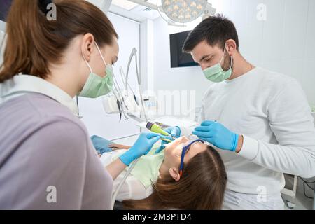 Erfahrener Zahnarzt in der Kariesbehandlung der Klientin Stockfoto