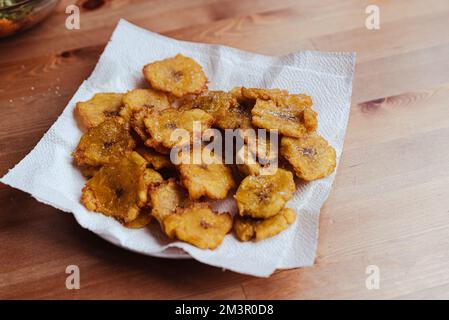 Gebratene Scheiben reifer Mehlbananen-Chips , traditionelle und beliebte Snacks und Beilagen in Mittel- und Südamerika, fotografiert über Kopf auf Leiste Stockfoto