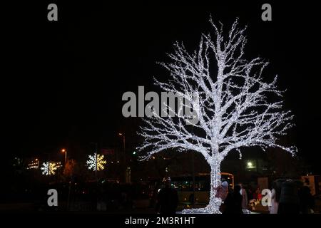 Istanbul, Türkei - 10. Dezember 2022: Ein normaler Baum mit Weihnachtsbeleuchtung in Kadikoy, Istanbul bei Nacht. Leute, die Spaß haben. Stockfoto