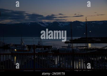 Abendlicher Sonnenuntergang vom Fischerdorf Husavik, isländische Kirche mit Blick auf den Atlantischen Ozean Stockfoto