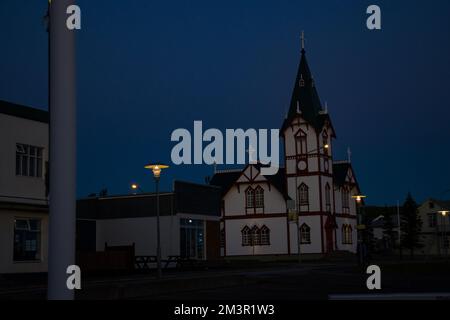 Abendlicher Sonnenuntergang vom Fischerdorf Husavik, isländische Kirche mit Blick auf den Atlantischen Ozean Stockfoto