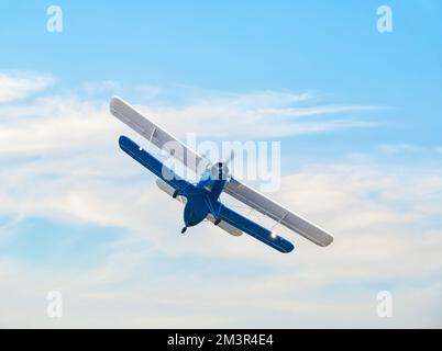 Ein sowjetischer Antonov an-2, einmotoriger Doppeldecker, der gegen den blauen Himmel fliegt. Stockfoto