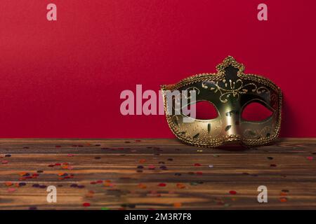 Karneval Maske in der Nähe der roten Wand Stockfoto