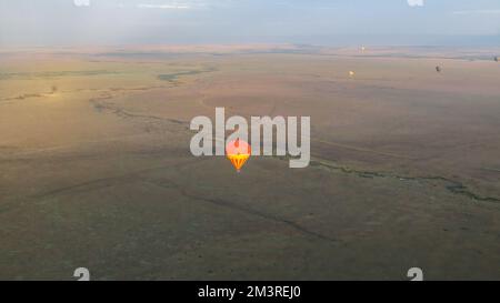 Ein einziger Heißluftballon, der über das Baumlose Grasland fliegt, ein Luftballon Stockfoto