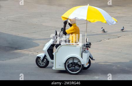 Ein Eisverkäufer fährt ein motorisiertes Dreirad auf der Straße Stockfoto