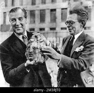 Sir David Eccles, Minister für Arbeit, hielt den neu entdeckten Leiter von Mithras, während seines Besuchs an dem Ort in Walbrook in der Londoner Stadt, wo der Tempel von Mithras im Jahr 1954 entdeckt wurde. Herr W.F. Grimes (rechts) Direktor der Ausgrabungen war zu dieser Zeit Direktor des Museum of London. Datum: 1954 Stockfoto