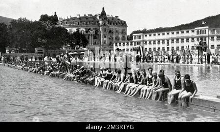 Badende genießen das Leben am Meer im Baden, das für seine Thermalquellen bekannt ist. In den 1920er Jahren wurde ein Lido errichtet, 16 km von Wien entfernt, um mehr Besucher anzulocken. Große Mengen Sand wurden in Lastwagen und LKWs auf ein 6 Hektar großes Gelände importiert, wo ein neues Badehaus gebaut wurde. Es gab ein Freiluftbad mit einer Größe von 360 x 145 Fuß, in dem 2000 Badende gleichzeitig untergebracht werden konnten. 1926 Stockfoto