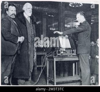 Leon Theremin (1896 - 1993) demonstriert sein elektronisches Musikinstrument einer Gruppe eingeladener Wissenschaftler (einschließlich Sir Henry Wood (links) und Sir Oliver Lodge) im Savoy Hotel. Theremin ist ein russischer und sowjetischer Erfinder und berühmt für seine Erfindung des Theremins, eines der ersten elektronischen Musikinstrumente und das erste, das in Massenproduktion produziert wurde. Stockfoto