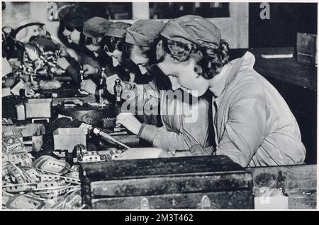 Weibliche Arbeiterinnen bei Vickers-Supermarine Works, Southampton, Großbritannien. Das Foto zeigt das Bohren und Stanzen von Löchern in Metall, die Komponenten für die Spitfire sind. Die Kampfflugzeuge der R.A.F. spielten eine wichtige Rolle bei den Vorkehrungen, die getroffen wurden, um das Land vor Luftangriffen zu schützen. Datum: Februar 1939 Stockfoto