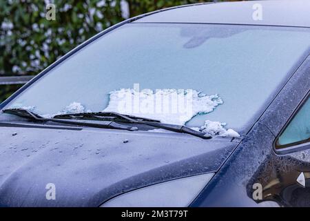 Eine vereiste Windschutzscheibe an einem Auto am frühen Morgen im Winter Stockfoto