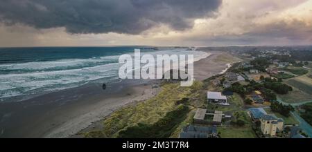 Sturmwolken bei Sonnenuntergang über Häusern an der Küste von Oregon. Stockfoto