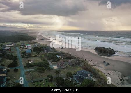 Sturmwolken bei Sonnenuntergang über Häusern an der Küste von Oregon. Stockfoto