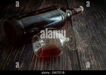 Liegen Gläser und eine Flasche Rotwein auf dem Tisch Stockfoto