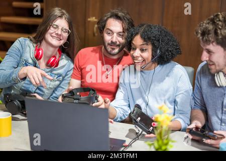 Ein Team von Gamern, jungen Menschen und verschiedenen Influencer, die Spaß beim Testen von Headsets und tragbaren Geräten für Spiele, Streaming und Übertragung inf haben Stockfoto