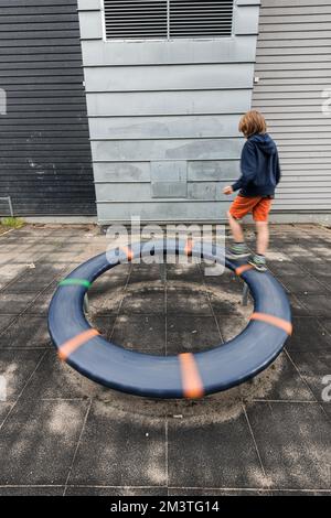 Lindesnes, Norwegen - Juli 19 2016: Kind läuft auf einem Drehrad auf einem Spielplatz Stockfoto