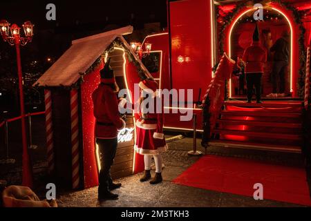 Zagreb, Kroatien - 8. Dezember 2022: Weihnachten Advent Coca-Cola Wohltätigkeitsfeier. Die Elfen des Weihnachtsmanns verteilen Limonadenflaschen an die Stadtbewohner. Hell Stockfoto