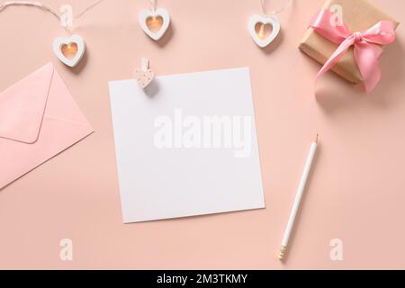 Valentinstag-Grußkarte mit Herzen, leerem, pinkfarbenem Umschlag und Geschenk auf pinkfarbenem Hintergrund. Blick von oben. Speicherplatz kopieren. Stockfoto