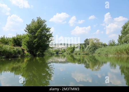 Antike multimillionäre Kreideberge auf der Steppenoberfläche der Erde. Weiße Kreideberge in einer Landschaft mit Fluss und grünen Bäumen Stockfoto