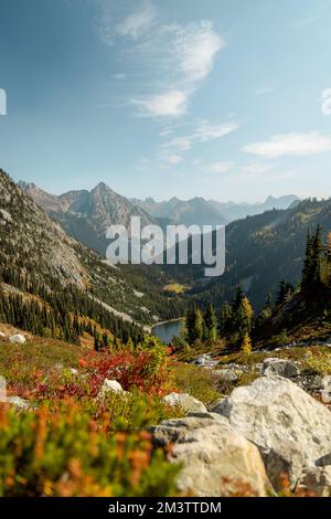 Vertikales Weitwinkelfoto von üppigen hohen Berghöhen riesige Nadelbäume abseits des Pfades mit Bergsee unten im North Cascades National Park im Norden Stockfoto