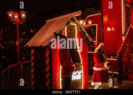 Zagreb, Kroatien - 8. Dezember 2022: Weihnachten Advent Coca-Cola Wohltätigkeitsfeier. Die Elfen des Weihnachtsmanns verteilen Limonadenflaschen an die Stadtbewohner. Hell Stockfoto