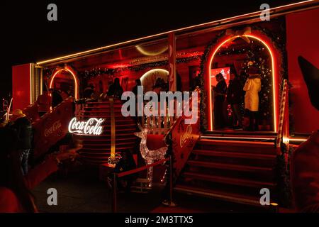 Zagreb, Kroatien - 8. Dezember 2022: Leuchtend bunte rote Dekorationen von Coca Cola bei den Adventsgemeinnützigen Feiertagen. Große Weihnachtsbälle in der Nähe eines glänzenden Trucks Stockfoto