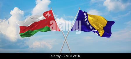 Zwei gekreuzte Flaggen Bosnien und Herzegowina und Oman winken im Wind am bewölkten Himmel. Beziehungskonzept, Dialog, Reisen zwischen zwei Ländern. 3D Stockfoto