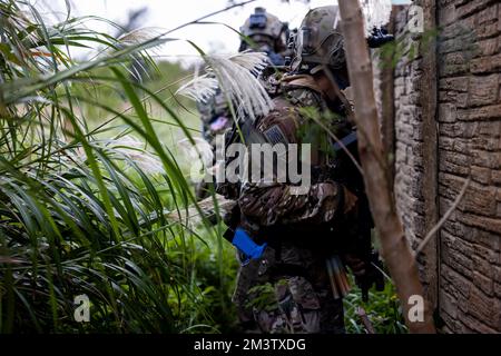 USA Army Green Berets mit der 1. Special Forces Group (SFG) weisen Marines mit der Marine Wing Support Squadron (MWSS) 171 bei einem Feldeinsatz in Camp Hansen, Okinawa, Japan, am 8. Dezember 2022 in Nahkampf-Taktiken in städtischem Gelände an. 1. die SFG wurde zusammen mit den Marines geschult, um die gemeinsame Letalität und die Fähigkeiten in städtischen Umgebungen zu verbessern. MWSS-171 hat diese Übung durchgeführt, um sich mit dem fortgeschrittenen Expeditionsbetrieb auf der Basis, dem Abbruchbetrieb, dem Stadtbetrieb und verschiedenen Waffensystemen vertraut zu machen. (USA Marinekorps Foto von PFC Justin J. Marty Stockfoto
