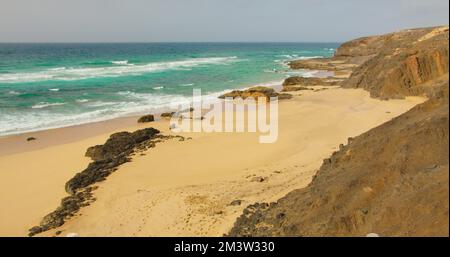 Leerer Sand Cofete Beach mit endlosem Horizont. Vulkanische Hügel im Hintergrund und Atlantik. Fuerteventura, Kanarische Inseln, Spanien. Playa de Stockfoto