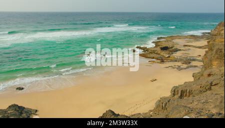 Paradies leerer gelber Sand Cofete Beach. Vulkanische Hügel im Hintergrund und Atlantik. Fuerteventura, Kanarische Inseln, Spanien. Playa de Cofete Stockfoto