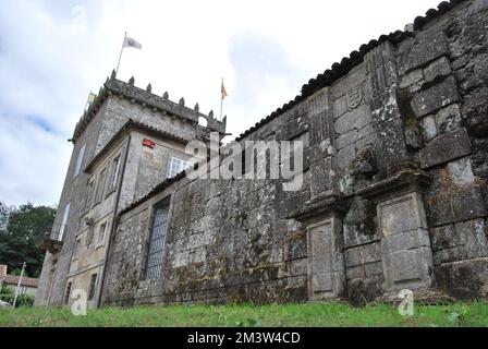 Das Äußere einer alten Architektur mit Flaggen auf der Spitze des historischen Wahrzeichens Pazo de Oca in Spanien Stockfoto