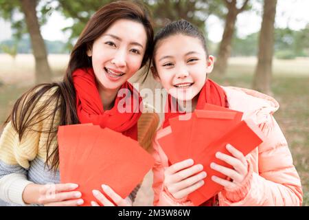 Frohes chinesisches Neujahr. asiatische Familie zeigt roten Umschlag als Glücksbringer Stockfoto