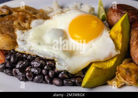 Nahaufnahme von Bandeja Paisa, typisch kolumbianisches Essen mit Eiern, Bohnen und Reis. Stockfoto