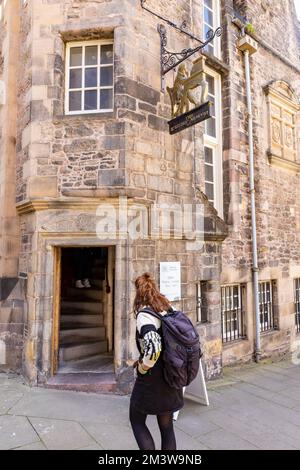 Eine junge Frau mit Rucksack stand vor dem Writers Museum auf der Royal Mile in Edinburgh, Schottland, Großbritannien, Sommer 2022 Stockfoto