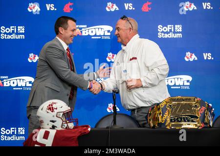 Der Cheftrainer von Washington State Cougars Jake Dickert schüttelt sich mit dem Cheftrainer von Fresno State Bulldogs Jeff Tedford die Hand, während Jimmy Kimmel LA Bowl Head spielt Stockfoto