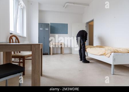 Nürnberg, Deutschland. 09.. Dezember 2022. Ein Mitarbeiter des Notschlafzentrums „Diana Hostel“ bereitet ein Zimmer vor. Ein ökumenisches Warmhaus ist an das Notschlafzentrum der Stadt angeschlossen, das im Frühjahr 2020 gegründet wurde und rund 80 Plätze hat. Dies dient als Tagsüber Treffpunkt und sorgt tagsüber für die Gäste des Notschlafzentrums. Kredit: Daniel Karmann/dpa/Alamy Live News Stockfoto