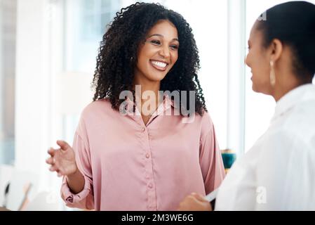 Gute Kommunikation bringt viel. Zwei junge Geschäftsfrauen, die sich in einem modernen Büro unterhalten. Stockfoto