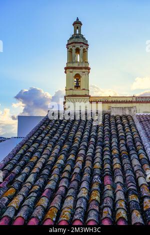 Kirchturm bei Sonnenuntergang mit den Dächern der alten arabischen Fliesen von Andalusien, Cadiz. Stockfoto