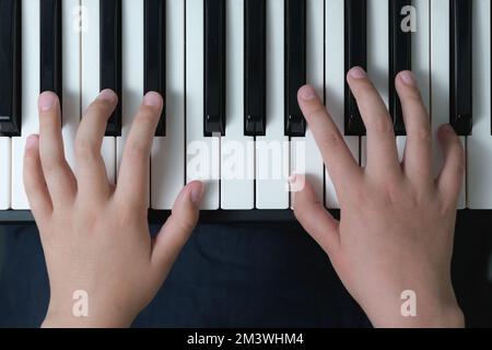 Die ersten Grundlagen der Musik. Finger eines Kindes auf der Klaviertastatur. Nahaufnahme Stockfoto