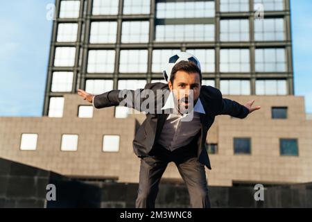 Bild eines Geschäftsmanns und Freispielers, der mit dem Ball auf der Straße Tricks macht. Konzept über Sport- und Geschäftsleute Stockfoto