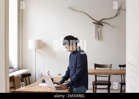 Positive beschäftigte indische Unternehmerin, die von zu Hause aus arbeitet Stockfoto