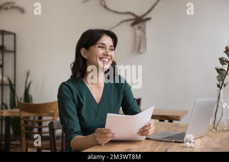 Fröhliche, junge, freiberufliche Geschäftsfrau mit rechtlichen Dokumenten Stockfoto