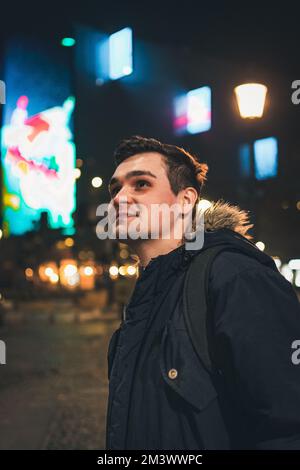 Ein vertikales Bild einer jungen Kaukasierin in der Nacht draußen Stockfoto